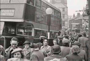 A historic bus image and people on a busy street